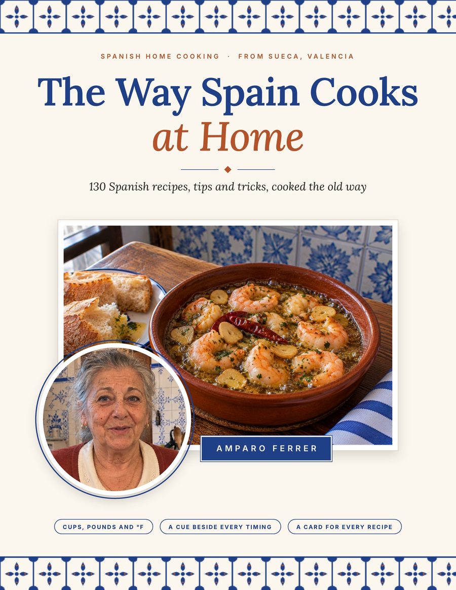 The cover of The Way Spain Cooks at Home: garlic prawns in a clay dish, with Amparo's portrait in a circle.
